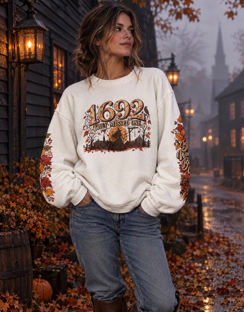 Model wearing the 1692 They Missed One witchy crewneck on a foggy historic autumn street.