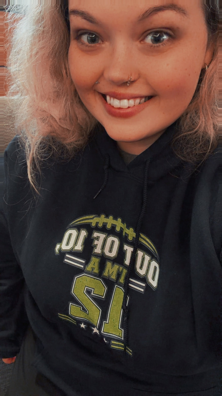 Founder modeling a navy game day hoodie with a lime green 12 graphic
